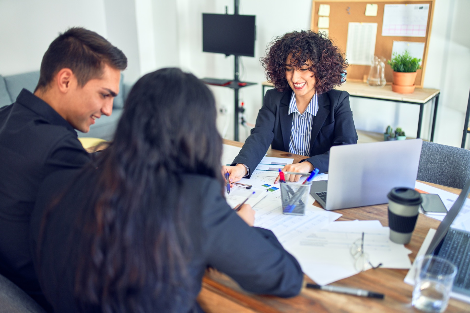 
Un jeune couple séduisant demande un prêt immobilier. Assis, souriant et heureux, ils rencontrent un agent immobilier et signent un prêt à la banque.