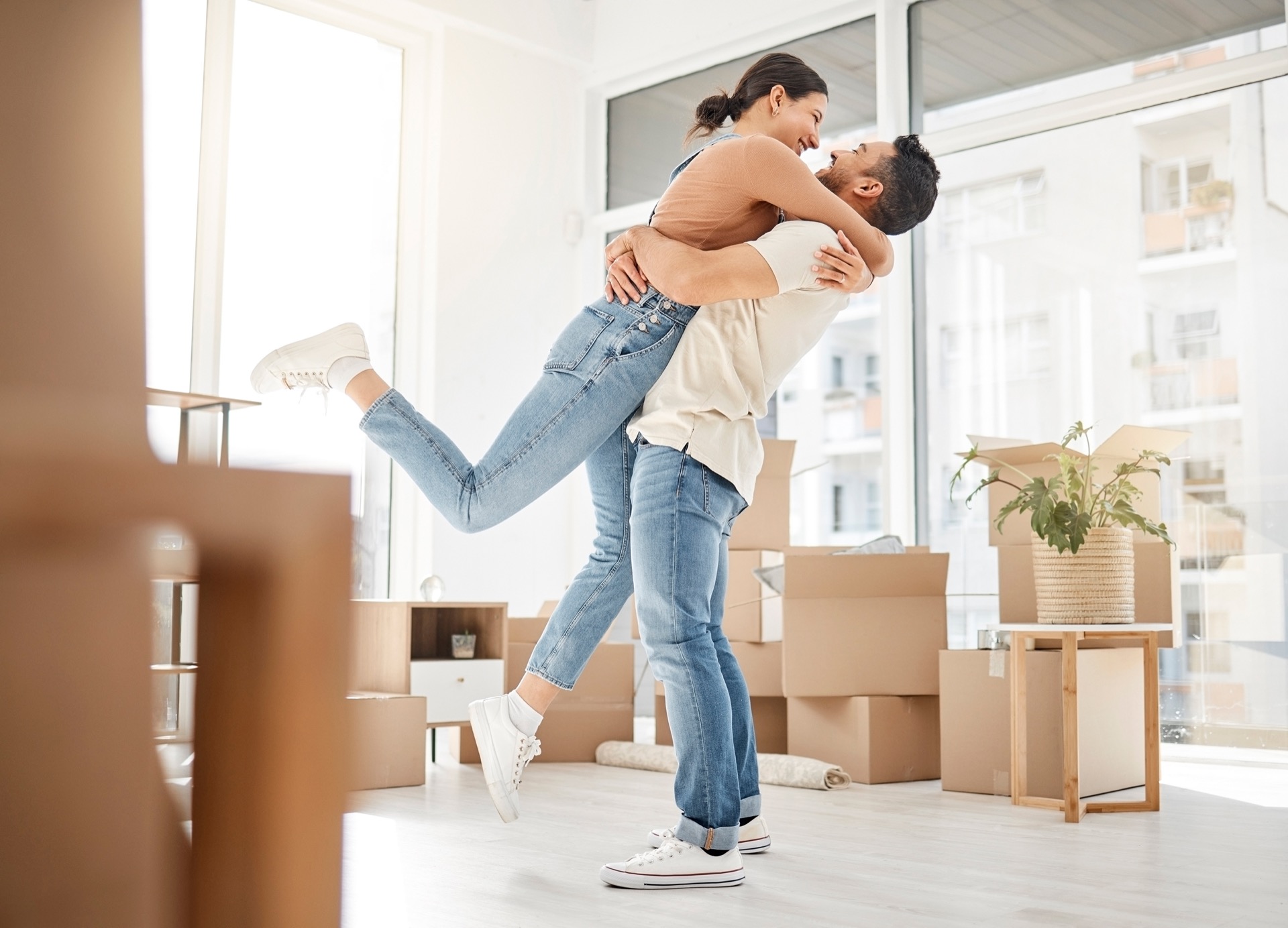 Amour, déménagement et câlins avec un couple dans une nouvelle maison pour célébrer, acheter et déménager. Excité, heureux et immobilier avec un homme et une femme dans un appartement avec salon pour investissement, location et achat.
