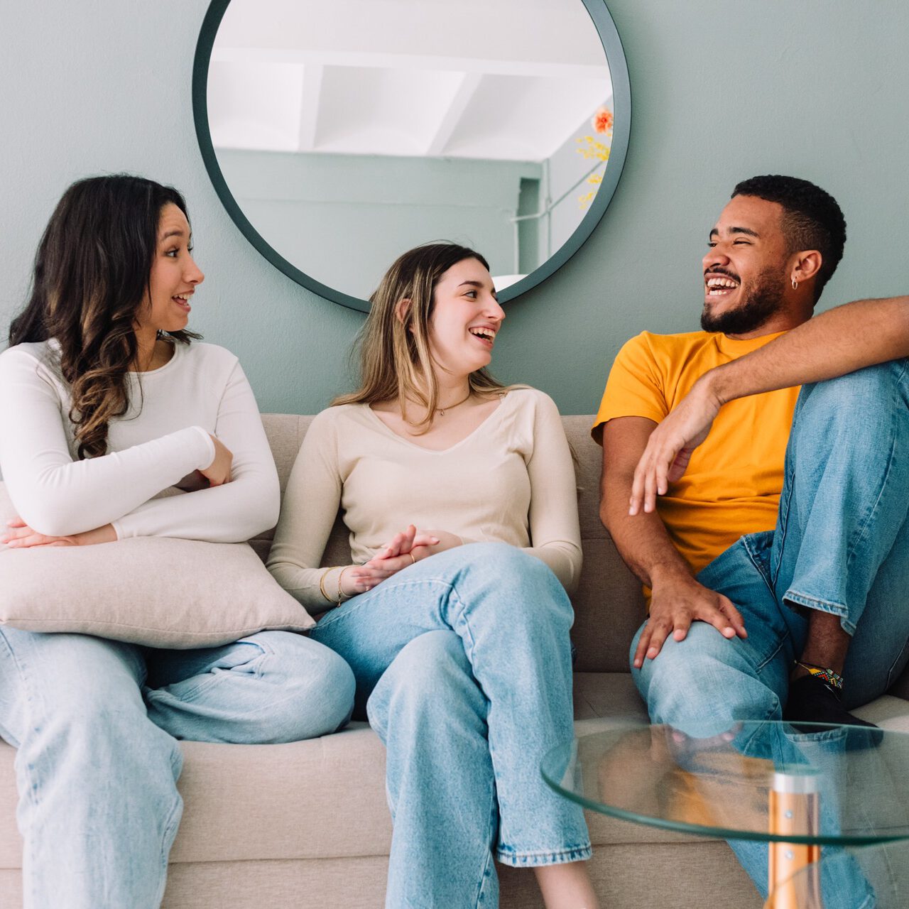 Groupe multiethnique d'amis se relaxant dans un logement étudiant